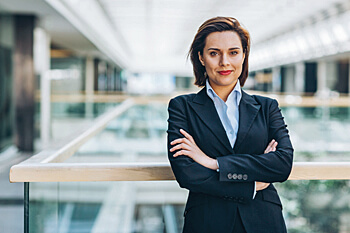 Geschäftsfrau lehnt an Glasbalustrade