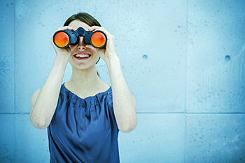 Frau guckt durch Fernrohr