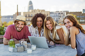 fröhliche junge Menschen vor Laptop