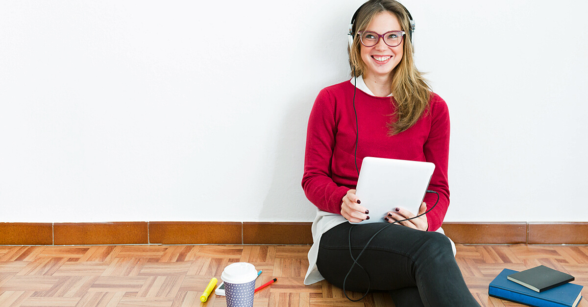 junge Frau sitzt auf dem Boden vor einem Ipad